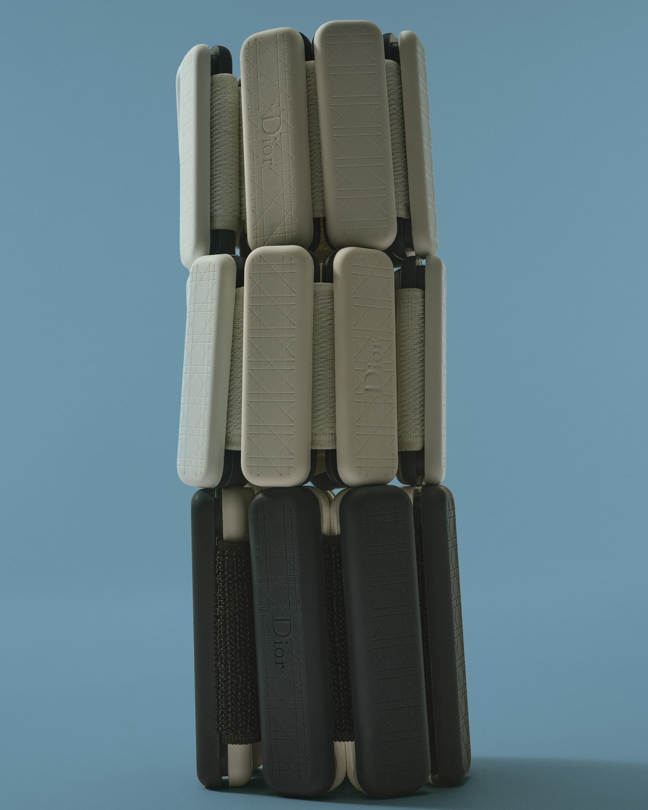 Dior Maison luxury wellness accessories in neutral tones on blue background.
