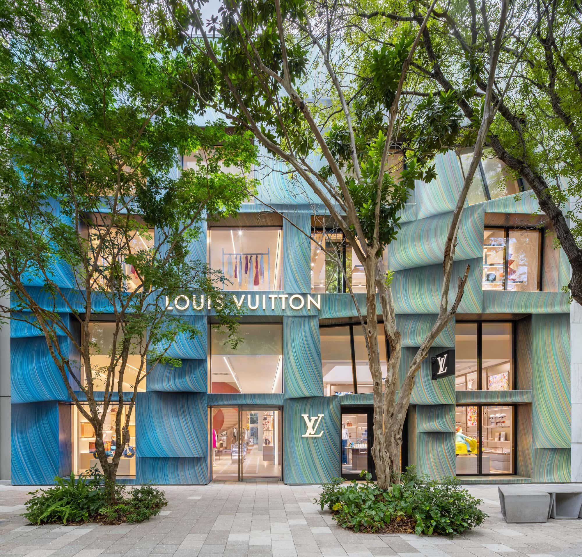 Louis Vuitton boutique in Miami Design District with colorful facade and trees.